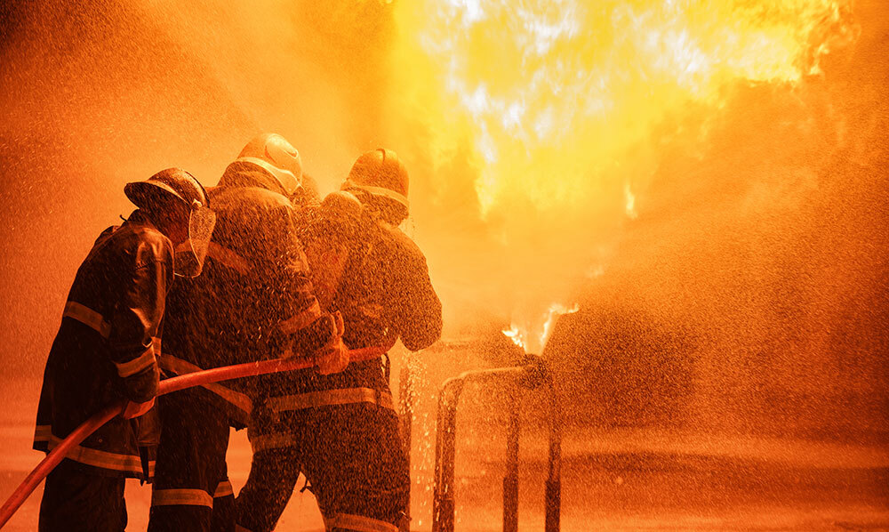 Three firemen putting out a fire