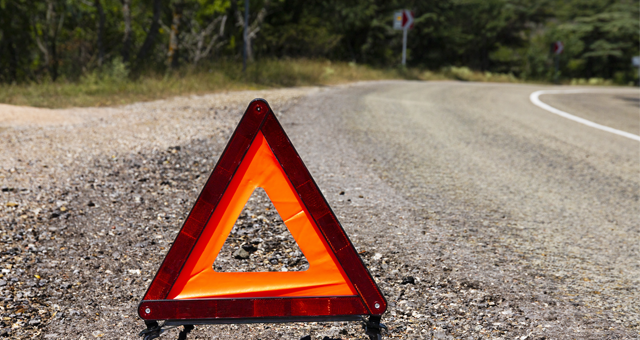 winding road with caution sign on the ground